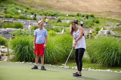 a woman and child playing golf on a golf course at Blue Mountain Resort Inn in Blue Mountains