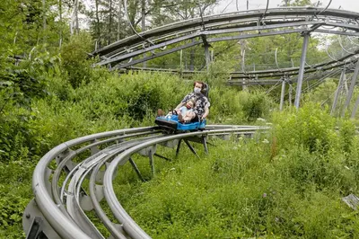 a woman and a child riding on a toy train at Blue Mountain Resort Home Collection in Blue Mountains