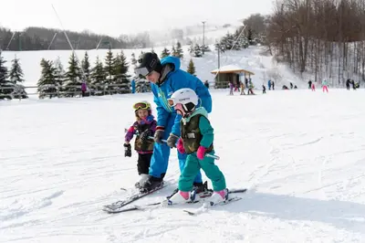 a man and two children on skis in the snow at Blue Mountain Resort Mosaic Suites in Blue Mountains