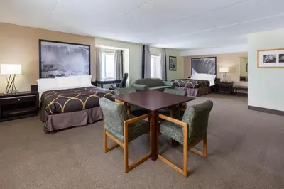 a hotel room with a bed and a table and chairs at Super 8 by Wyndham Niagara Falls by the Falls in Niagara Falls