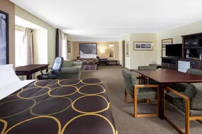 a hotel room with a bed and a living room at Super 8 by Wyndham Niagara Falls by the Falls in Niagara Falls