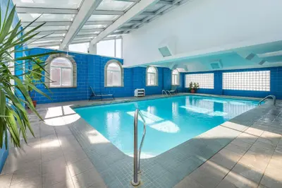 a large swimming pool in a building at Super 8 by Wyndham Niagara Falls by the Falls in Niagara Falls