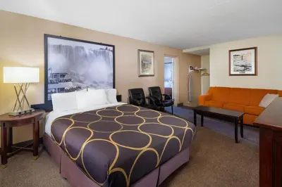 a hotel room with a bed and a couch at Super 8 by Wyndham Niagara Falls by the Falls in Niagara Falls