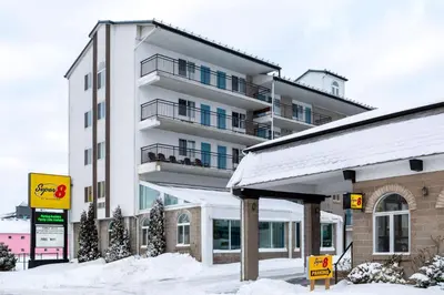 a building with snow on the ground in front of it at Super 8 by Wyndham Niagara Falls by the Falls in Niagara Falls