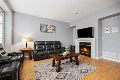 a living room with leather furniture and a fireplace at Amazing Spacious house in Center of Richmond hill in Richmond Hill
