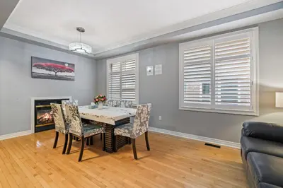 a dining room with a table and chairs and a fireplace at Amazing Spacious house in Center of Richmond hill in Richmond Hill