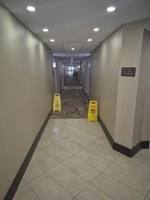 a hallway with two yellow signs on the floor at Comfort Inn in Fort Erie