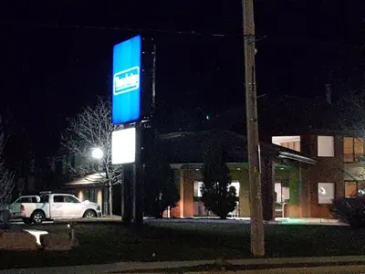 a blue sign in front of a building at night at Travelodge by Wyndham Welland in Welland