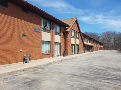 an empty parking lot next to a brick building at Travelodge by Wyndham Welland in Welland
