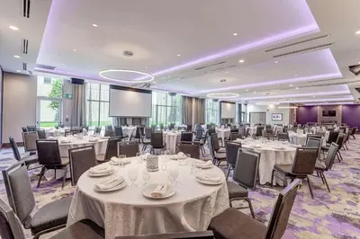 a banquet room with tables and chairs and a projection screen at Hilton Garden Inn Toronto/Brampton West, Ontario, Canada in Brampton