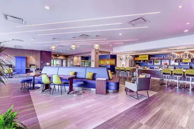 a hotel lobby with a bar and tables and chairs at Home2 Suites By Hilton Toronto/Brampton, On in Brampton