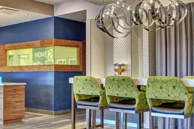 a dining room with a table with chairs and a chandelier at Home2 Suites By Hilton Toronto/Brampton, On in Brampton