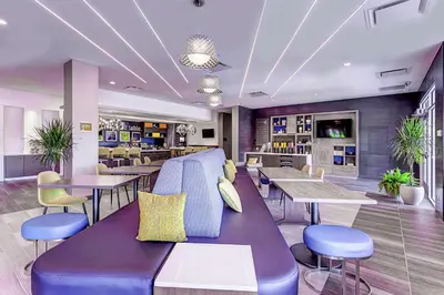 a restaurant with a purple bench and tables and chairs at Home2 Suites By Hilton Toronto/Brampton, On in Brampton