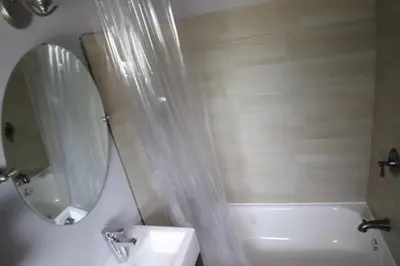 a bathroom with a tub and a sink and a mirror at Walkerton Inn Motel in Walkerton
