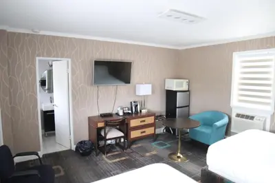 a hotel room with a desk and a bed at Walkerton Inn Motel in Walkerton