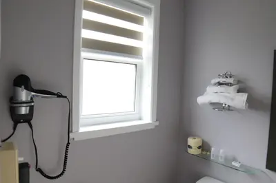 a bathroom with a window and a sink with towels at Walkerton Inn Motel in Walkerton