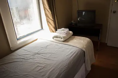 a bedroom with a bed and a window with towels at Saint Lawrence Residences and Suites in Toronto