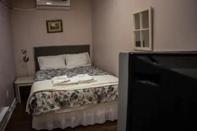 a small bedroom with a bed with towels on it at Saint Lawrence Residences and Suites in Toronto