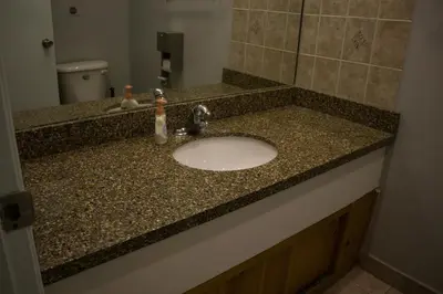 a bathroom counter with a sink and a mirror at Saint Lawrence Residences and Suites in Toronto