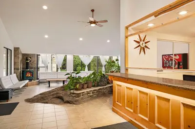 a living room with a ceiling fan and a fireplace at Howard Johnson by Wyndham Gravenhurst in Gravenhurst