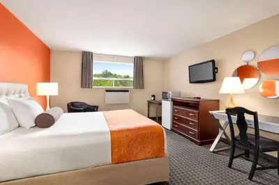 a hotel room with a bed and a desk and a television at Howard Johnson by Wyndham Gravenhurst in Gravenhurst
