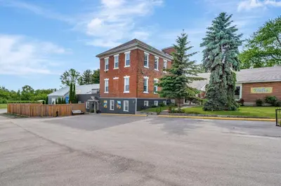 an empty parking lot in front of a brick building at The Bloomfield Inn in Bloomfield