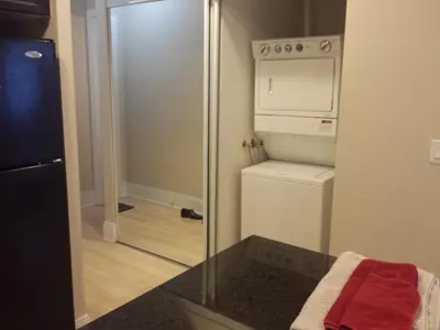 a small kitchen with a refrigerator and a washer and dryer at SPECTACULAR VIEW, 2 BEDROOMS FURNISHED CONDO and BEST LOCATION in Mississauga
