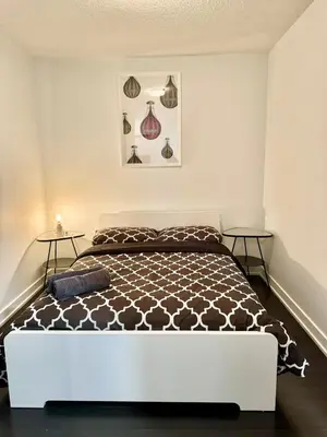 a bedroom with a bed and two side tables at Cozy Condo near CN Tower in Toronto