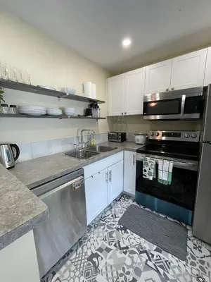 a kitchen with a sink and a stove top oven at Comfortable and Convenient Apartment in Central Niagara in St. Catharines
