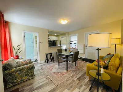 a living room with a table and a dining room at Comfortable and Convenient Apartment in Central Niagara in St. Catharines