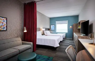 a hotel room with two beds and a couch at Home2 Suites By Hilton Brantford in Brantford
