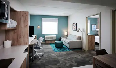 a living room with a couch and a desk in a room at Home2 Suites By Hilton Brantford in Brantford