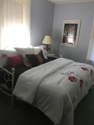 a bedroom with a bed with a white comforter at Pemberley House Bed and Breakfast in Seaforth