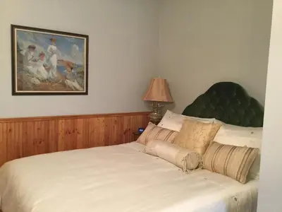 a bedroom with a white bed with a green headboard at Pemberley House Bed and Breakfast in Seaforth