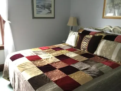 a bed with a colorful quilt on it in a bedroom at Pemberley House Bed and Breakfast in Seaforth