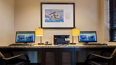 a desk with three computers and a printer at Best Western London Airport Inn & Suites in London