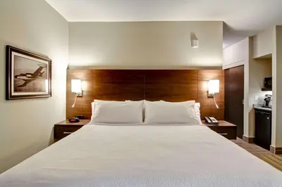 a large bed in a hotel room with two lamps at Best Western London Airport Inn & Suites in London