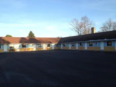 an empty parking lot in front of a building at American Plaza Motel in London