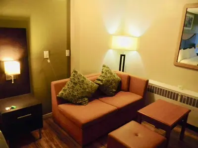 a living room with a couch in a hotel room at American Plaza Motel in London