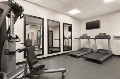 a gym with several tread machines and mirrors at Country Inn & Suites by Radisson, Belleville, ON in Belleville