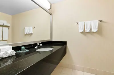 a bathroom with a sink and a mirror and towels at Best Western Inn On The Bay in Owen Sound