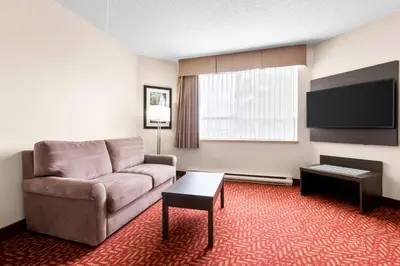 a living room with a couch and a flat screen tv at Best Western Inn On The Bay in Owen Sound