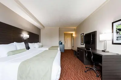 a hotel room with two beds and a desk at Best Western Inn On The Bay in Owen Sound