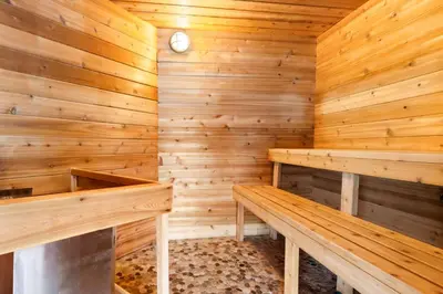 a sauna with two benches and a clock at Best Western Inn On The Bay in Owen Sound