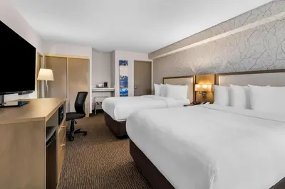 a hotel room with two beds and a flat screen tv at Best Western Halton Hills in Georgetown