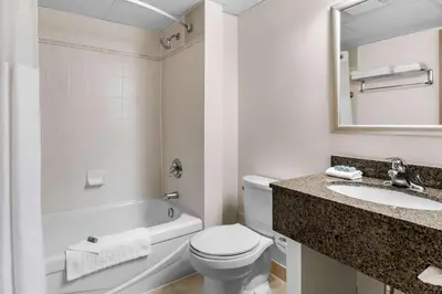 a bathroom with a toilet and a sink and a mirror at Best Western Halton Hills in Georgetown