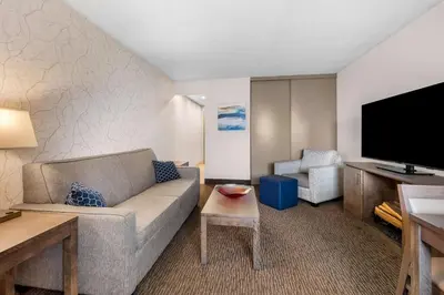 a living room with a couch and a flat screen tv at Best Western Halton Hills in Georgetown