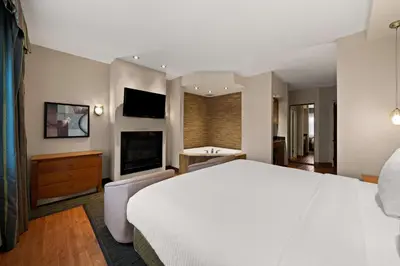 a hotel room with a white bed and a television at Best Western Plus Orangeville Inn & Suites in Orangeville
