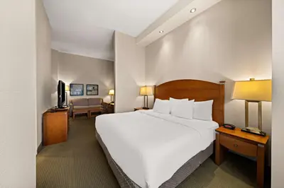 a hotel room with a large bed and a television at Best Western Plus Orangeville Inn & Suites in Orangeville