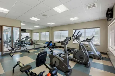 a gym with several treadmills and elliptical machines at Best Western Plus Walkerton Hotel & Conference Centre in Walkerton